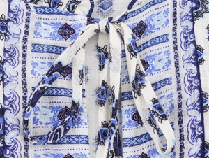 Détail de l'encolure à imprimé bohème bleu et blanc avec lien à nouer et texture du tissu