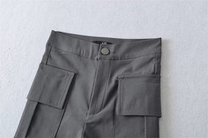 Detail view of dark grey cargo shorts with utility pockets and button closure