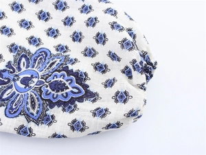 Gros plan sur tissu en lin blanc avec imprimé paisley bleu et poignet élastique froncé