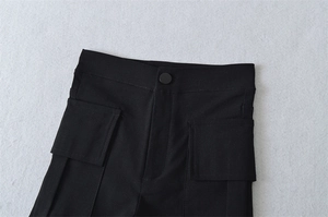 Detail of black utility shorts showing matte button closure and durable twill fabric texture