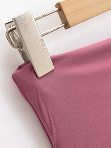Dettaglio della maglia a coste sul girovita dei pantaloni larghi color malva