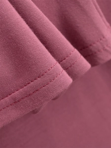 Dettaglio della cucitura a doppio ago sull'orlo dei pantaloni larghi in cotone rosa scuro