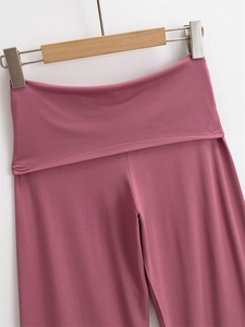 Dettaglio della vita alta con risvolto su pantaloni larghi dritti rosa polvere