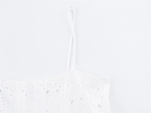 Gedetailleerde opname van wit broderie anglaise borduurwerk op een zomerse camisole top