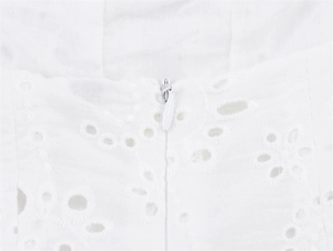 Detailopname van wit broderie-anglaise katoen met een naadloze onzichtbare ritssluiting