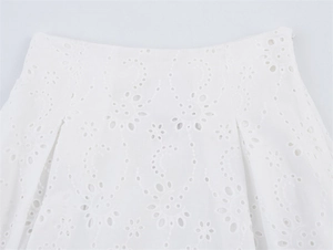 Detail van de witte katoenen rok met fijn borduurwerk en geometrische patronen