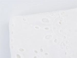 Detailopname van wit Broderie Anglaise katoen met delicaat bloemig borduursel