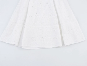 Detail van wit broderie anglaise borduurwerk op de gelaagde zoom van een katoenen rok