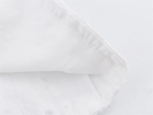 Detailopname van de geborduurde golvende zoom met fijn stiksel op witte textielstof