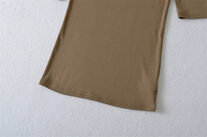 Close-up of double-needle stitched hem on slim-fit jersey cotton top in dark brown