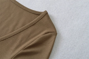 Detail of deep brown ribbed knit fabric with precise V-neck stitching and texture