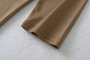 Close-up of brown ribbed knit sleeve cuff showing high elasticity and fine stitching