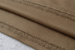 Detail view of double-needle coverstitch stitching on brown ribbed knit fabric