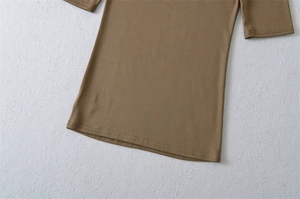 Close-up of the double-stitched hem and stretchy fabric of a slim fit knit top