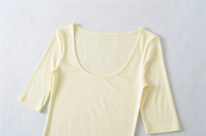 Close-up of beige scoop neck crop top with smooth elastic fabric texture details