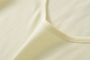 Close-up of low U-neckline with double-needle stitching on slim fit ribbed jersey top