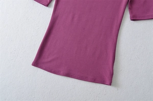 Detailed view of the double-stitched hem on a purple stretch slim-fit knit T-shirt