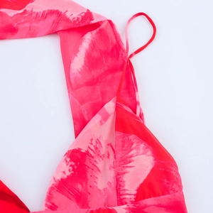 Detalle de estampado floral rosa degradado y tirantes finos en un vestido de gasa