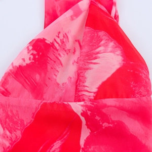 Gros plan sur le tissu en mousseline fleurie rose avec détails de plis croisés