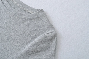 Close-up of the round neckline with double-needle stitching on a gray heather textured top