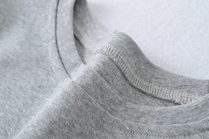 Detail of grey short sleeve dress showing fine double-needle stitching on the neckline
