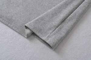 Detail of grey knitted short sleeve dress showing high-quality double-needle hem stitching