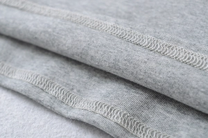 Macro view showing high-quality light gray knitted fabric with reinforced double-needle stitching