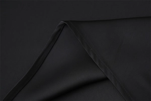 Dettaglio macro delle cuciture precise su tessuto in raso di acetato nero lucido