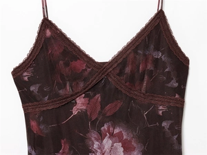 Detail van V-hals met kant en bloemenprint op een donkerbruine jurk met bandjes