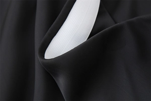 Vista macro del tessuto satinato nero con elastico bianco in vita e cuciture rifinite
