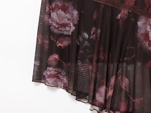Detail van bloemen mesh kant en vintage print op de jurk met onregelmatige zoomlijn