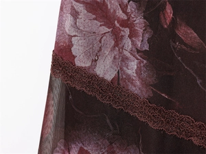 Detailopname van mesh stof met bloemenprint en verfijnde kanten rand aan de hals
