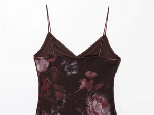 Detailopname van v-hals met kant en bloemenprint op een donkerbruine jurk met bandjes