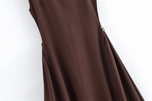 Detail van een donkerbruine zomerjurk met zilveren metalen gesp en elegante taille-stiksels