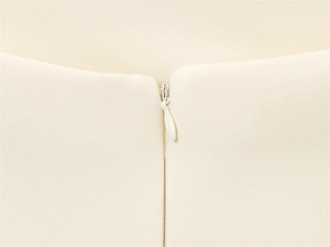 Detailansicht des unsichtbaren Reißverschlusses am weißen Sommerkleid aus Netzstoff