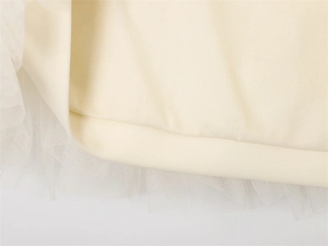 Detailansicht des leichten Tüllstoffs und des beigen Innenfutters des Sommerkleides