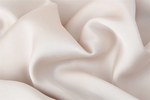 Dettaglio ravvicinato del tessuto in raso di acetato crema con elegante trama setosa