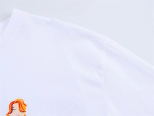 Detail von Rundhalsausschnitt und orangefarbener Illustration auf weißem T-Shirt