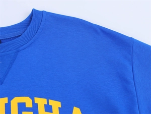 Detailed view of the ribbed crew neck and high-quality yellow letter print on blue shirt
