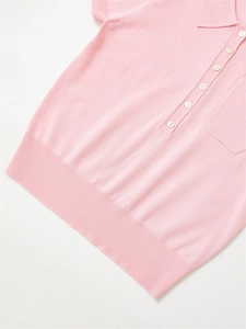 Gros plan du polo en maille rose avec boutons nacrés et détails de texture côtelée