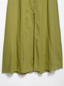 Detail of olive green linen midi dress hem with buttons and vertical seam texture