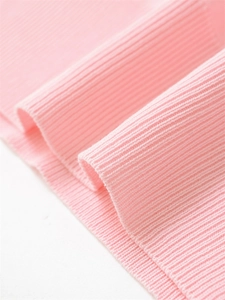 Gros plan du tissu tricoté rose pour polo montrant la texture côtelée verticale et souple