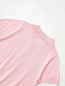 Gros plan sur le polo en maille rose avec col plat et détails de texture fins