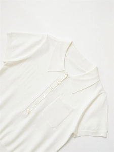 Détails des poignets côtelés et poches sur un polo en tricot blanc à manches courtes