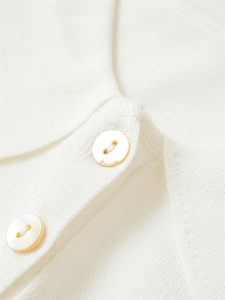 Détail de la maille fine du polo avec boutons en nacre et structure du col classique