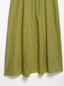 Detail view of emerald green linen midi dress hem showing natural fabric texture