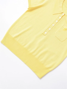 Détail du polo en maille jaune montrant les poignets côtelés et la patte à cinq boutons