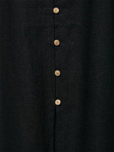 Detailed close-up of light-colored buttons on a black linen midi dress with fabric texture