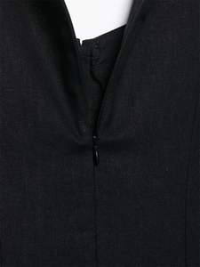 Detail view of the hidden back zipper on a black linen midi dress with woven texture