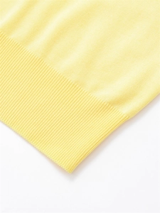 Gros plan sur l'ourlet en maille côtelée jaune clair et la texture du polo d'été